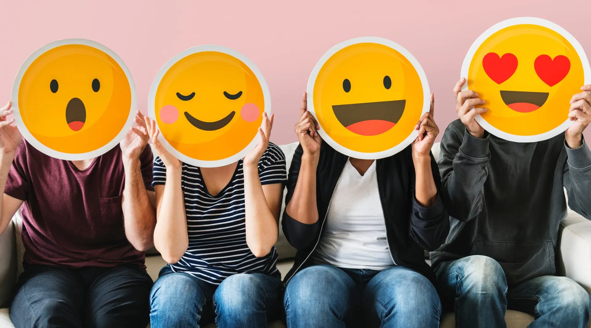 People holding emoji faces expressing joy and connection
